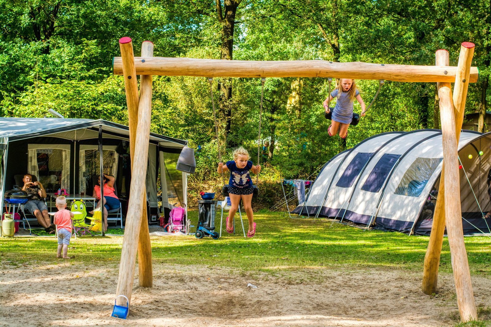 Kamperen op een veldje met uitzicht op een speeltuintje